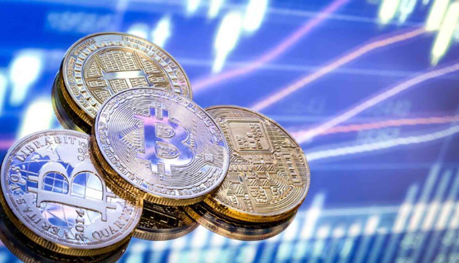 Moedas físicas representando Bitcoin empilhadas sobre um fundo azul com gráficos de cotação em alta, simbolizando o crescimento e a valorização das criptomoedas no mercado financeiro.