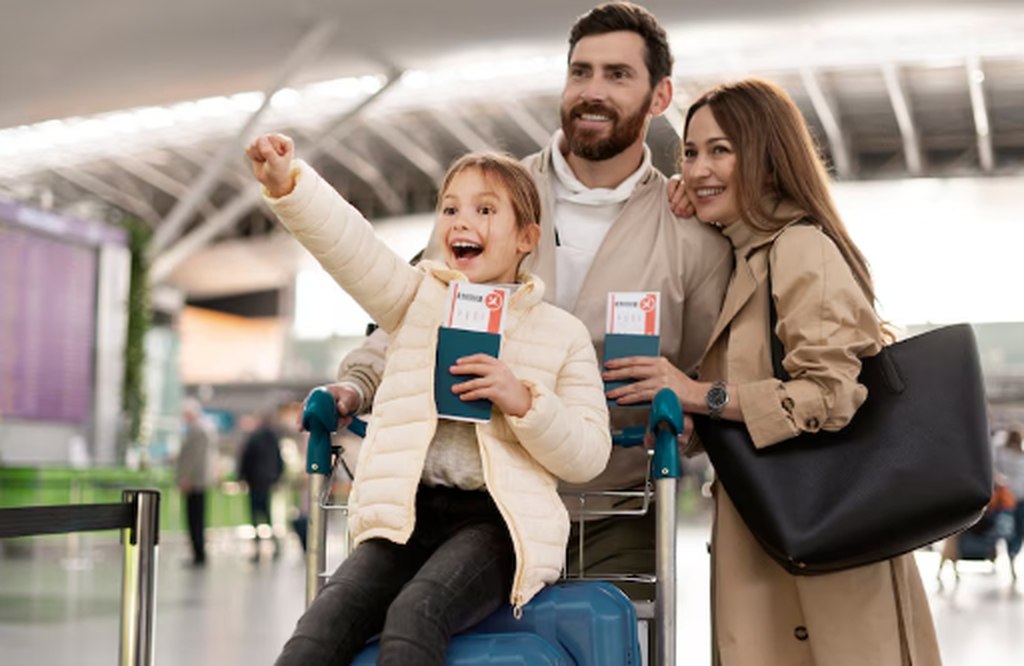 Família feliz no aeroporto com passaportes e bagagens, pronta para embarcar — representação ideal da importância do seguro viagem internacional para garantir tranquilidade durante o trajeto.